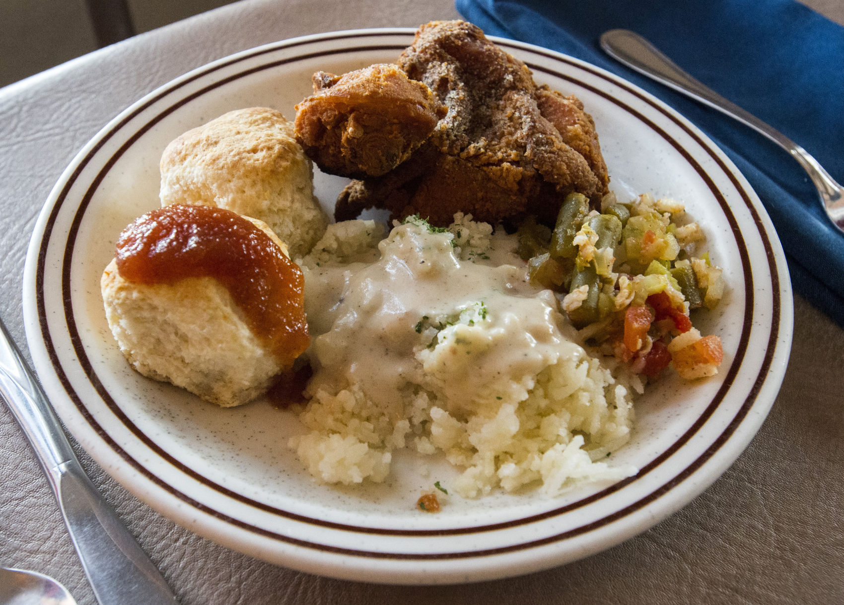 A serving of skillet-fried chicken, riced potatoes and cream gravy, okra casserole and homemade biscuits with apple butter Friday, April 7, 2017, at the Juniper Valley Ranch, 15 miles south of Colorado Springs. The family restaurant has been serving the same home-style meals since 1951. (The Gazette, Christian Murdock)